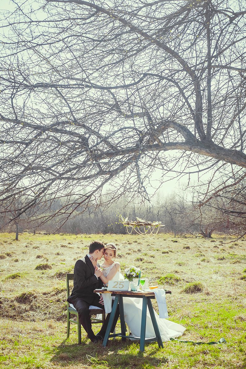 Стол и люстра в декоре свадебной фотозоны